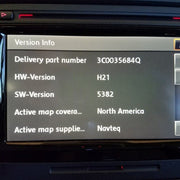An in-car navigation system displaying version information on the screen.